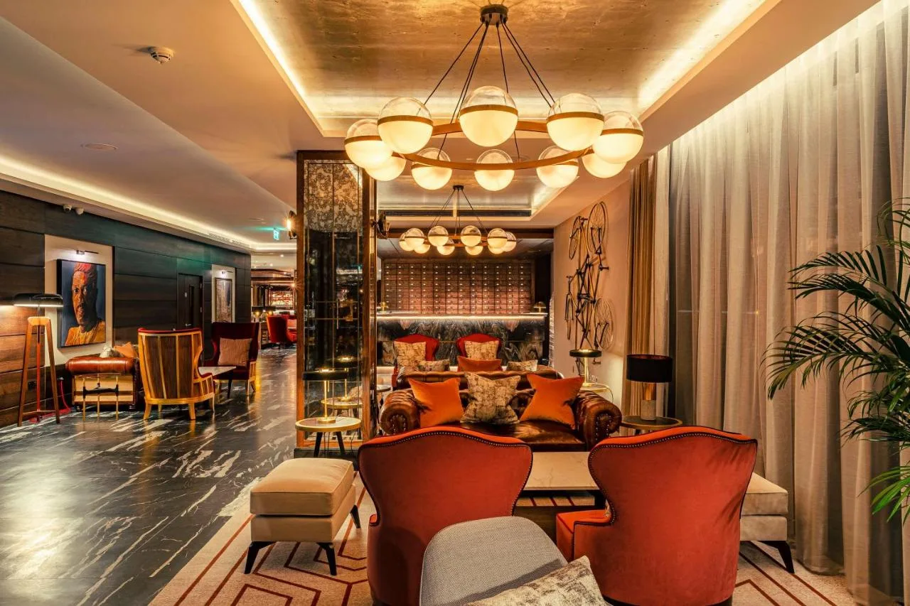 a lobby of a hotel with chairs and a table at The Fellows House Cambridge, Curio Collection By Hilton in Cambridge