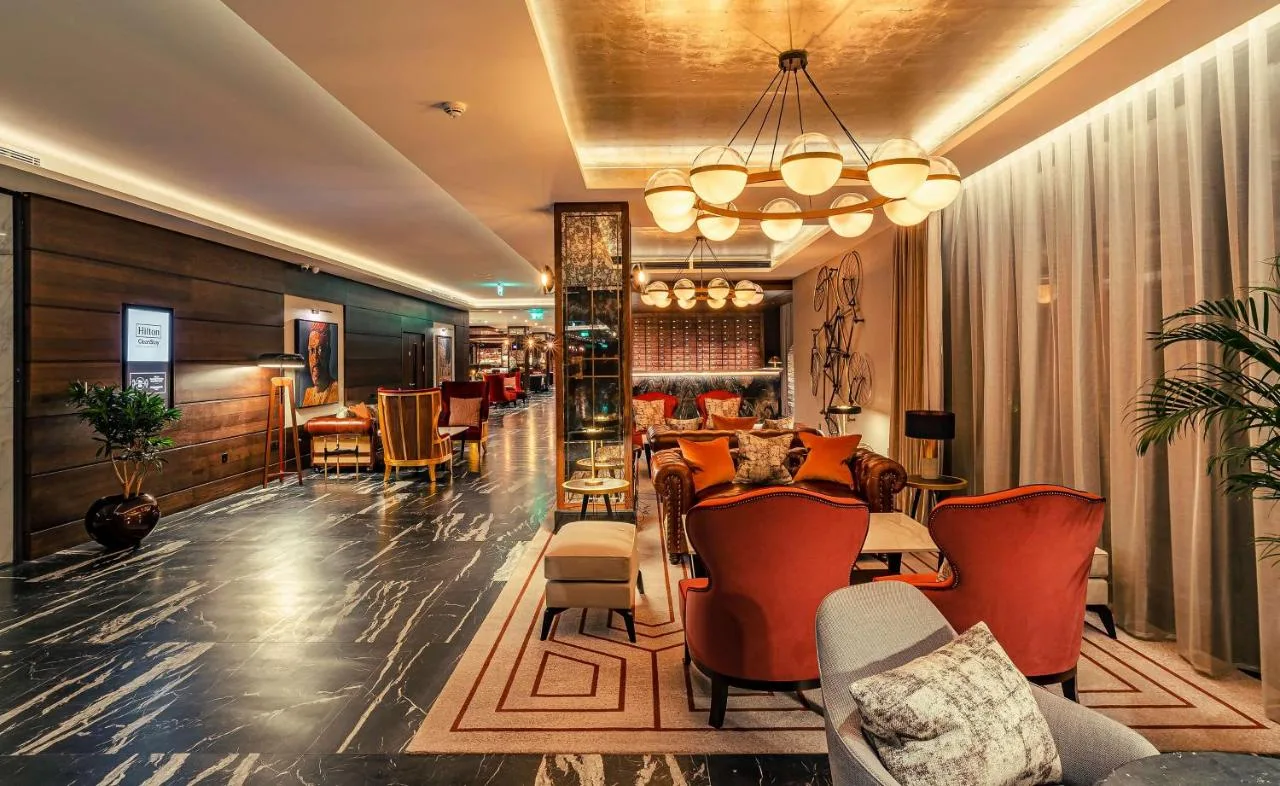 a lobby of a hotel with chairs and tables at The Fellows House Cambridge, Curio Collection By Hilton in Cambridge
