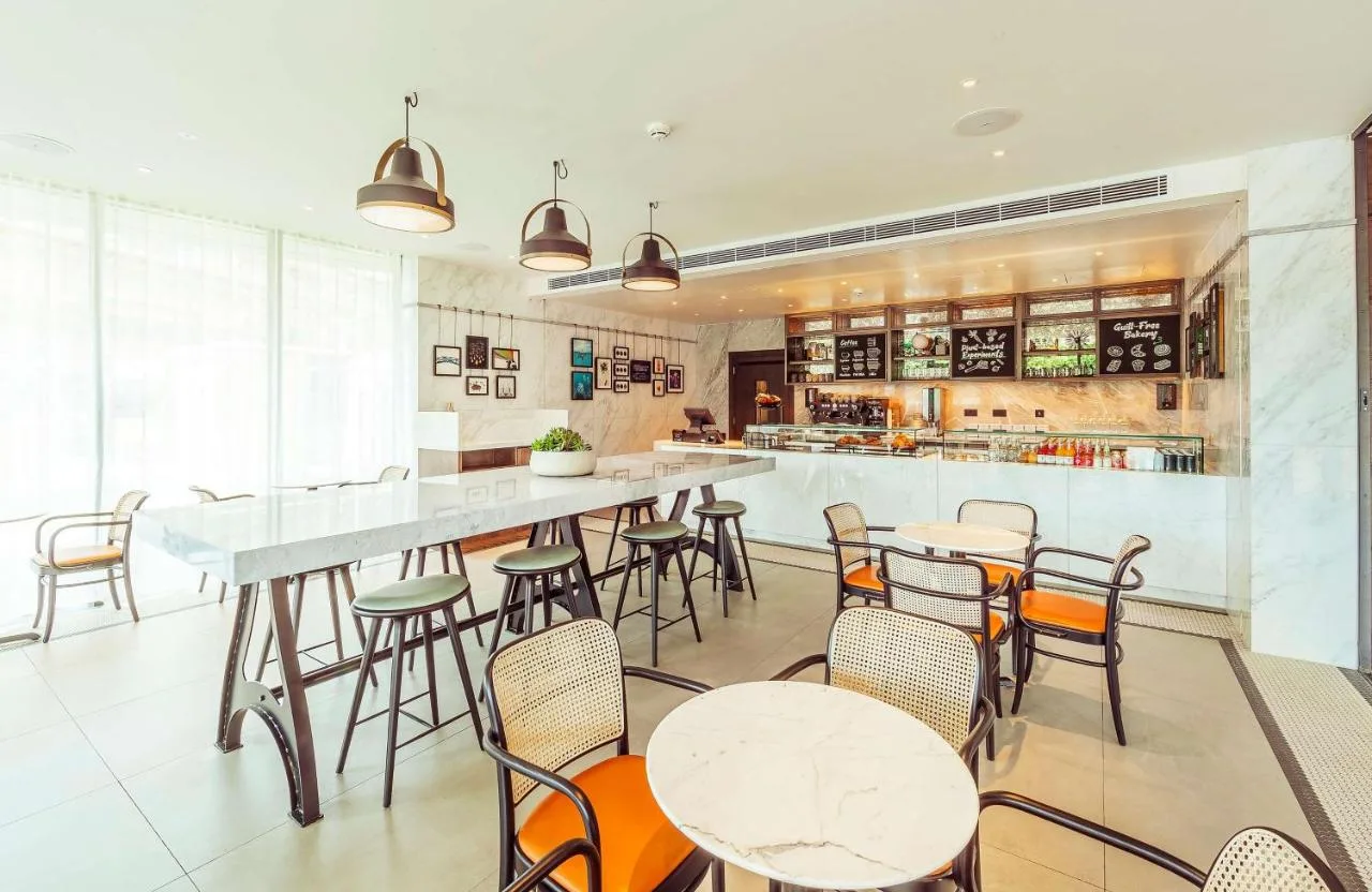 a restaurant with tables and chairs and a bar at The Fellows House Cambridge, Curio Collection By Hilton in Cambridge